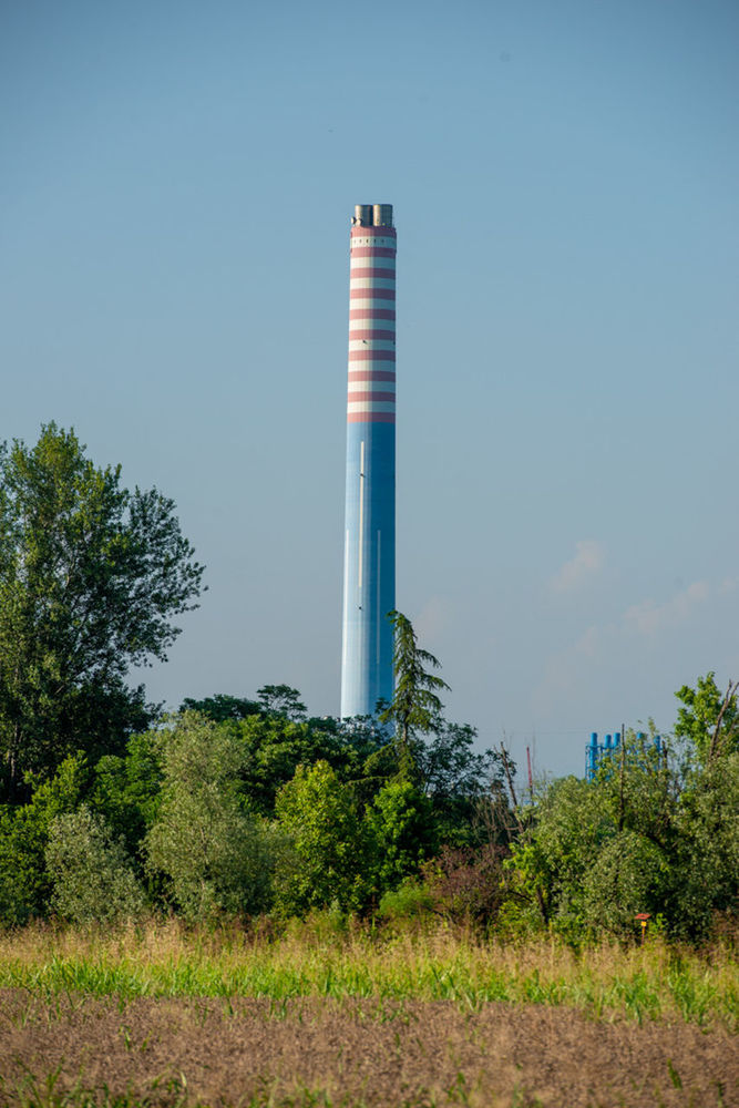 plant, sky, tower, tree, nature, industry, factory, no people, environment, architecture, built structure, power generation, blue, day, building exterior, outdoors, environmental issues, technology, clear sky, smoke stack, landscape, pollution, land