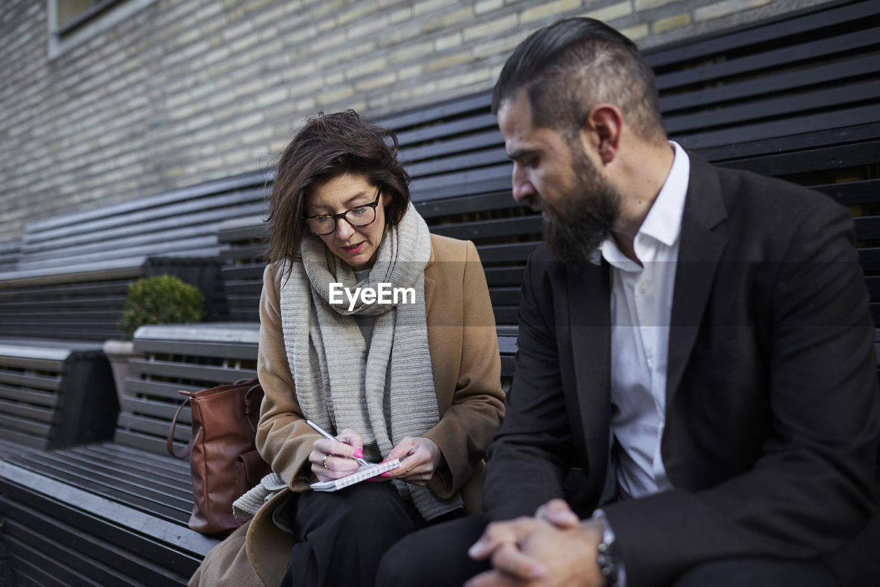 Colleagues sitting on bench and planning