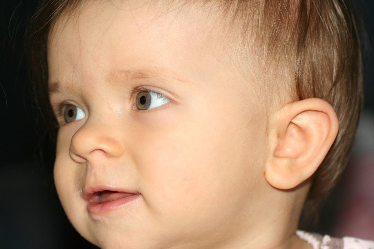 CLOSE-UP OF BABY GIRL WITH HAND