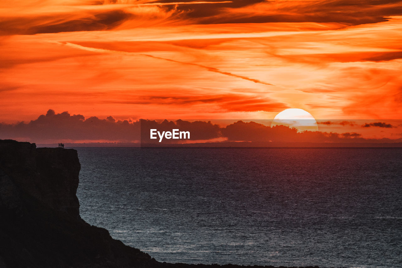 Scenic view of sea against orange sky