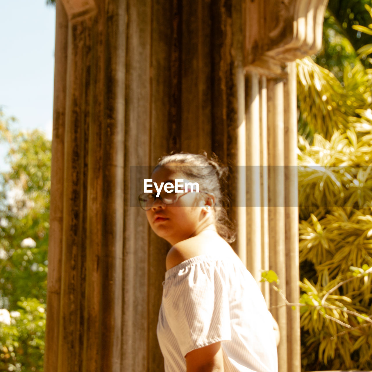 PORTRAIT OF YOUNG MAN STANDING BY TREE