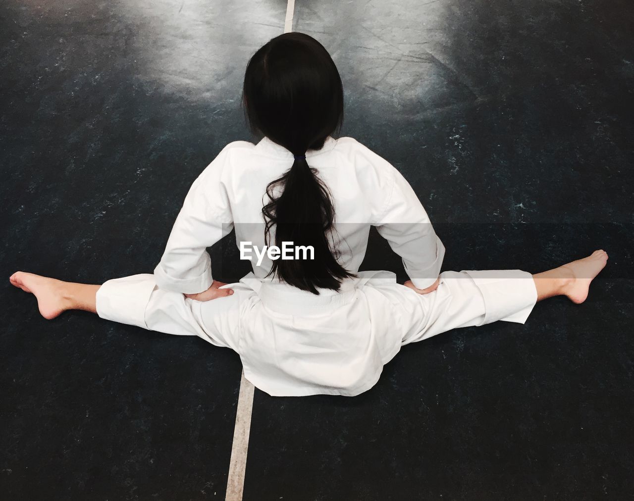 Rear view of girl doing splits in class
