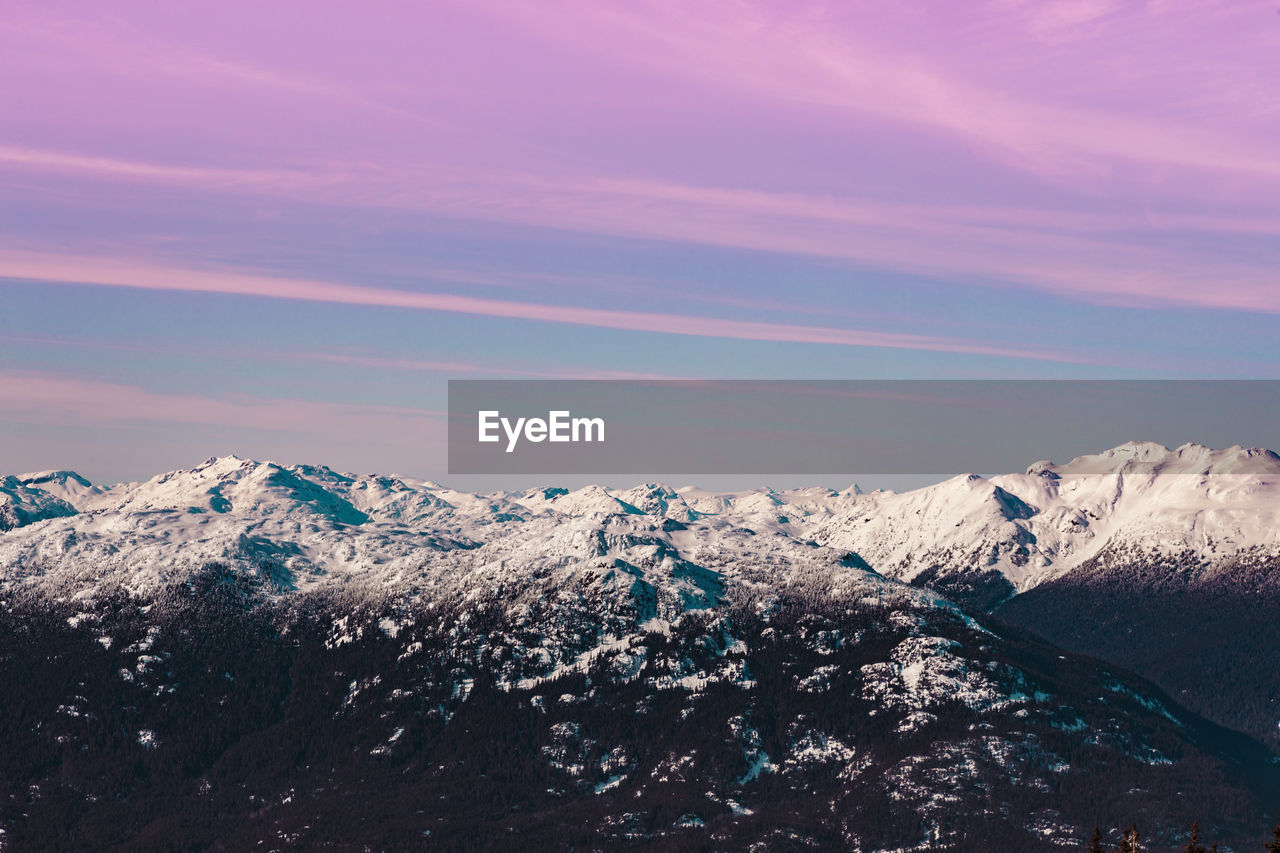 Scenic view of snowcapped mountains against sky during sunset