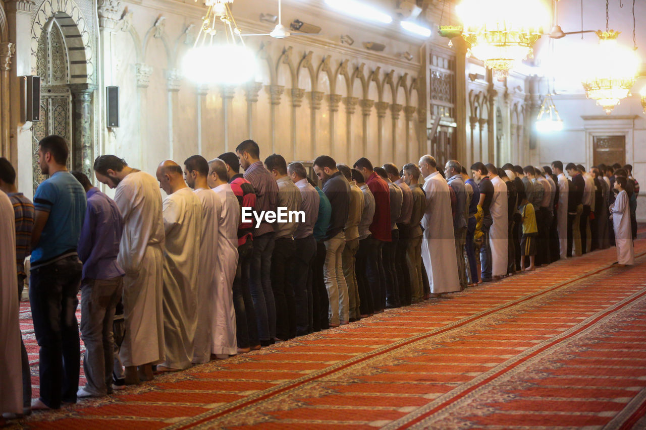 GROUP OF PEOPLE IN ILLUMINATED TEMPLE