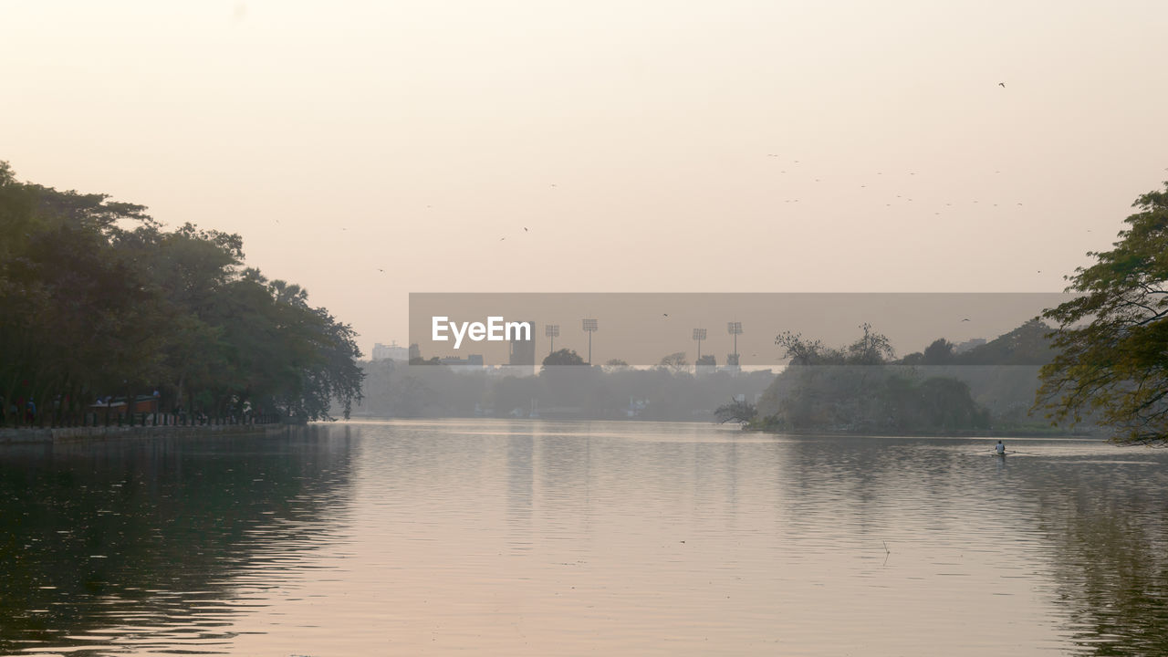 SCENIC VIEW OF LAKE AGAINST SKY AT SUNSET