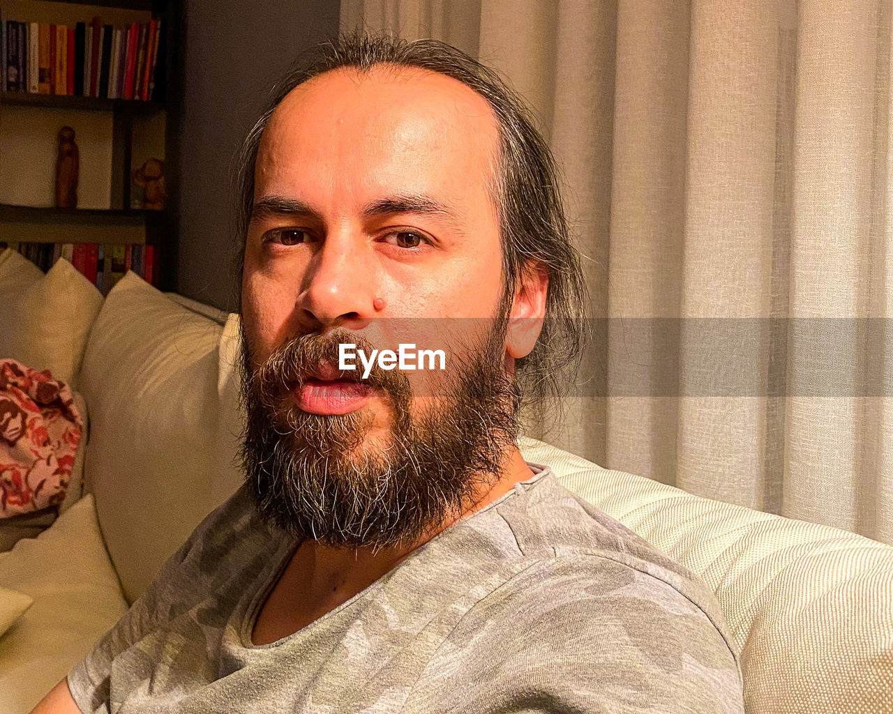 Portrait of man sitting on sofa at home