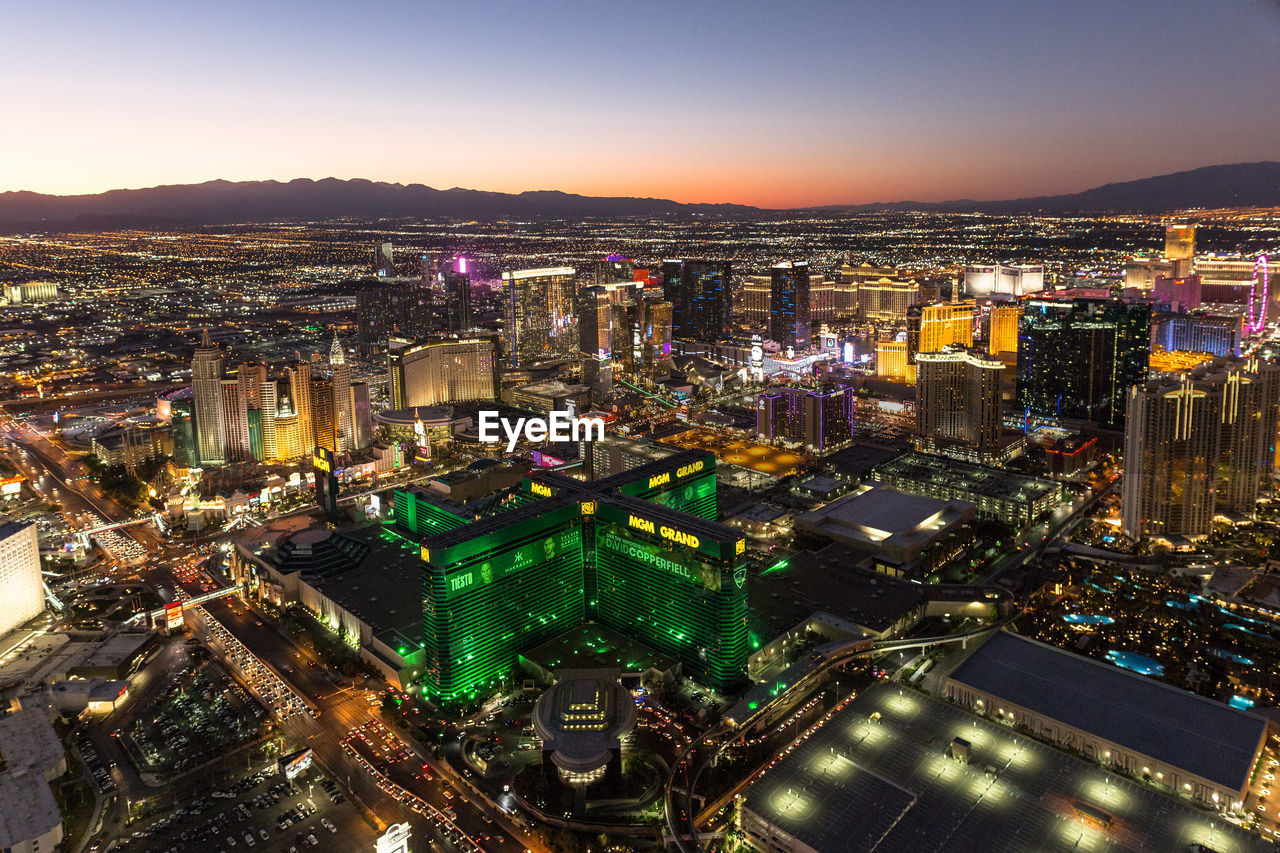 HIGH ANGLE VIEW OF ILLUMINATED CITY AT NIGHT