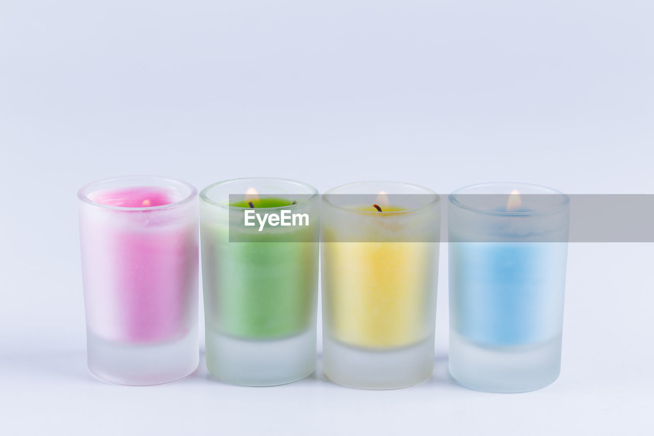 Close up view of colorful candles over white background