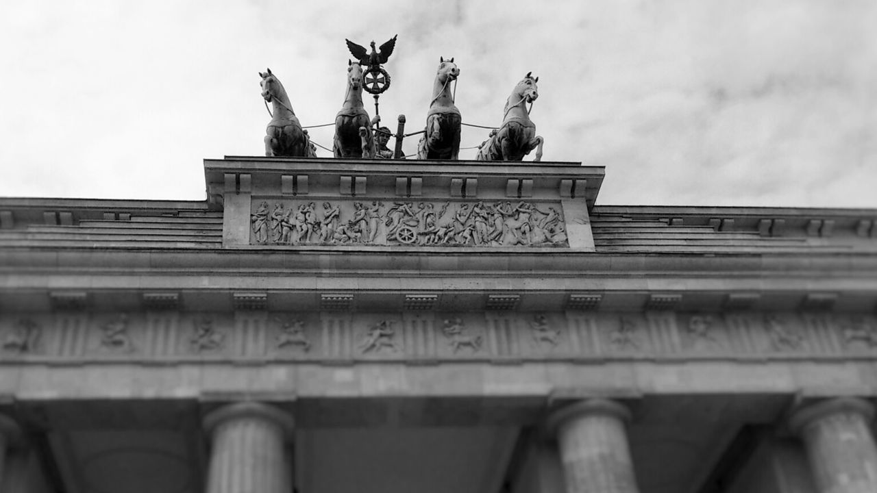 Low angle view of horses on brandenburg gate against sky