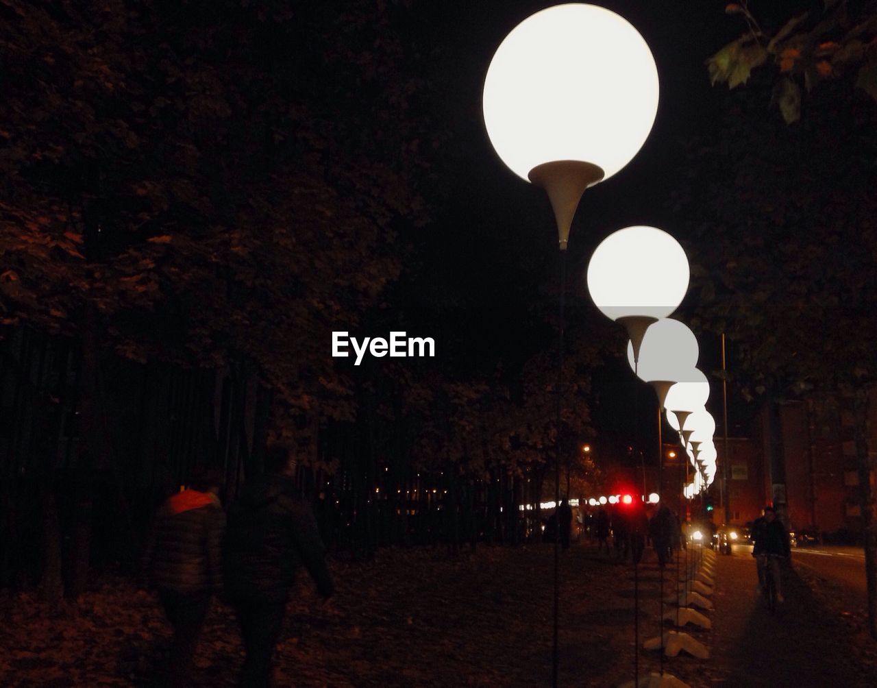 Illuminated street light on street at night