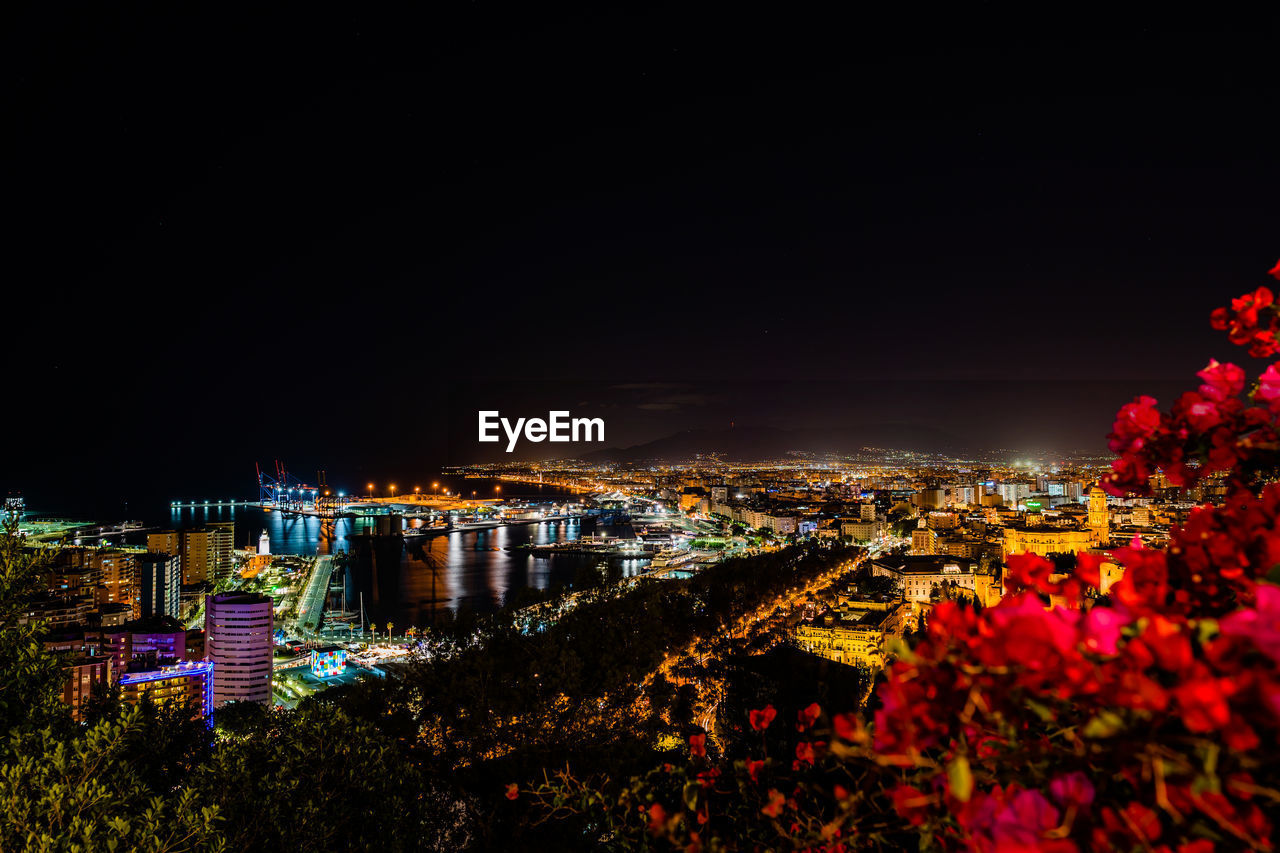 High angle view of illuminated buildings against sky at night