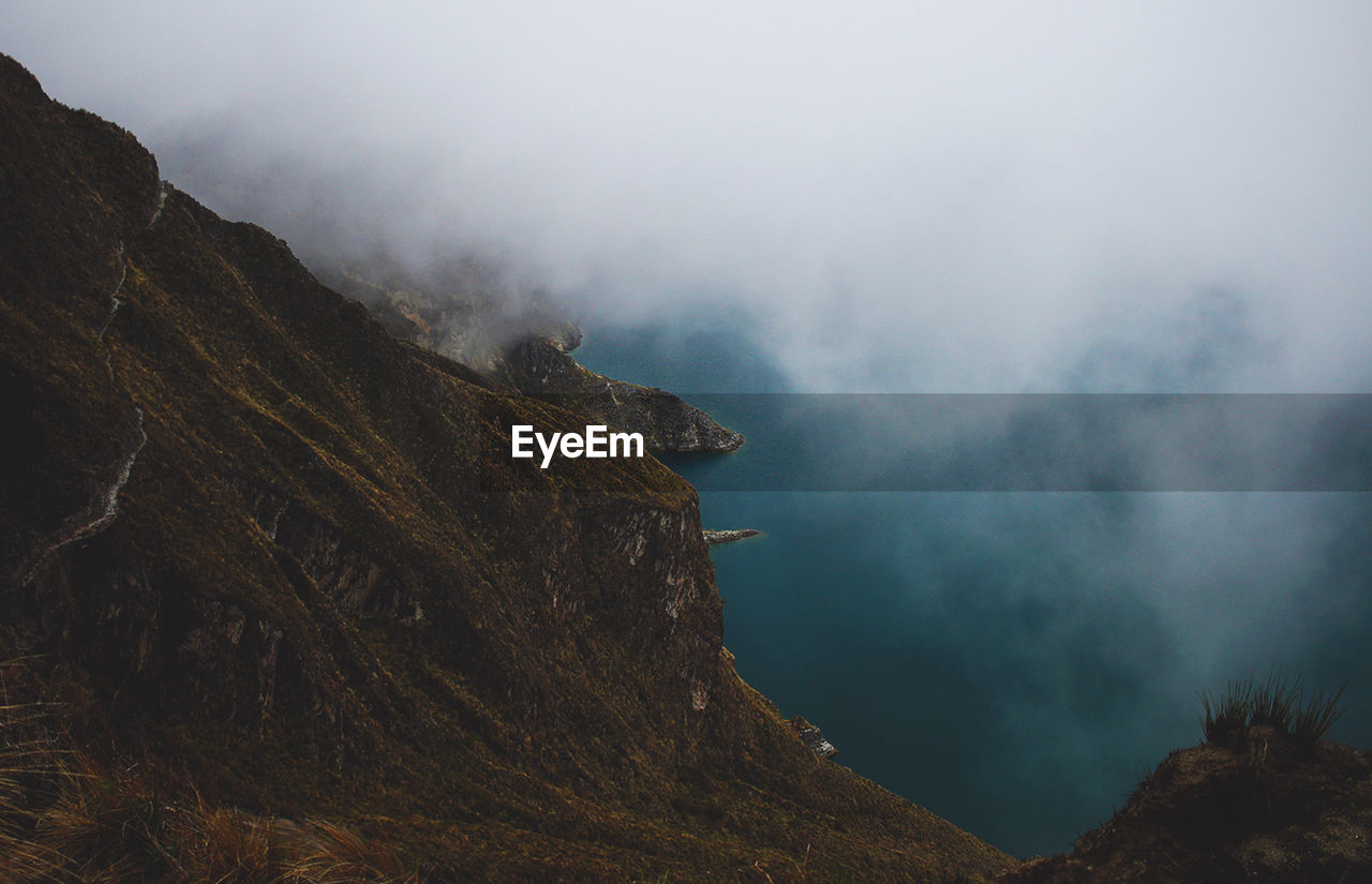 Scenic view of mountains against cloudy sky