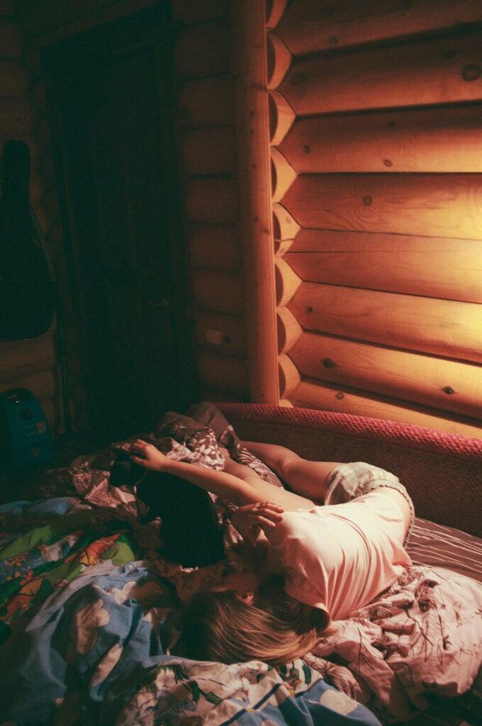 WOMAN SLEEPING ON BED IN BEDROOM