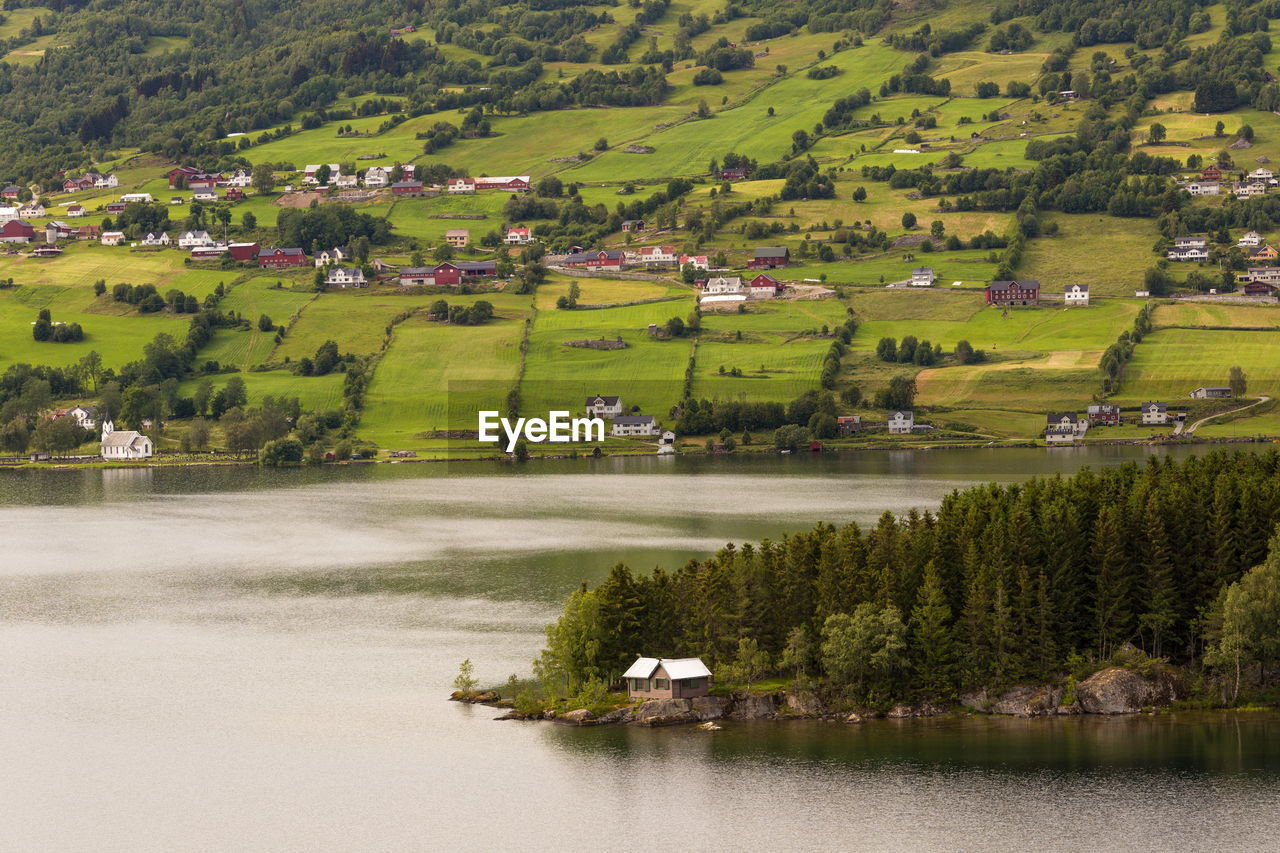 Scenic view of green landscape and houses against sky