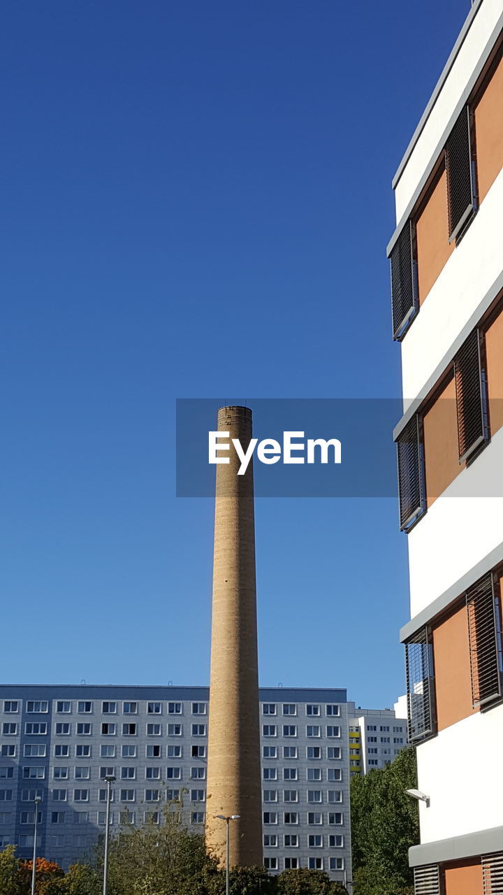 Low angle view of buildings against clear blue sky