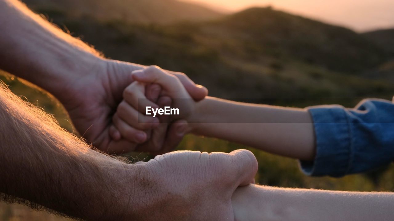 cropped image of man holding hands outdoors