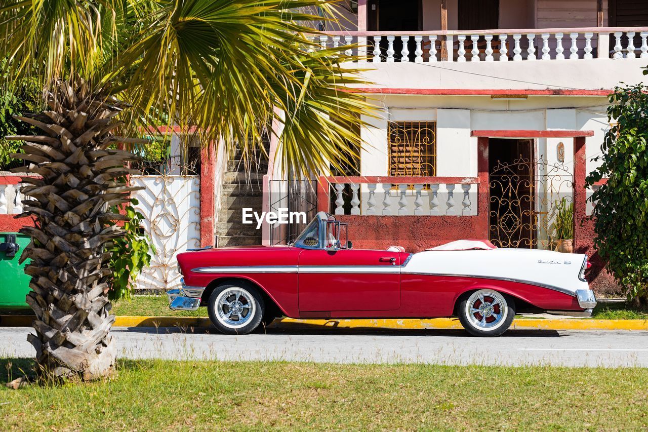 VINTAGE CAR ON STREET BY BUILDING