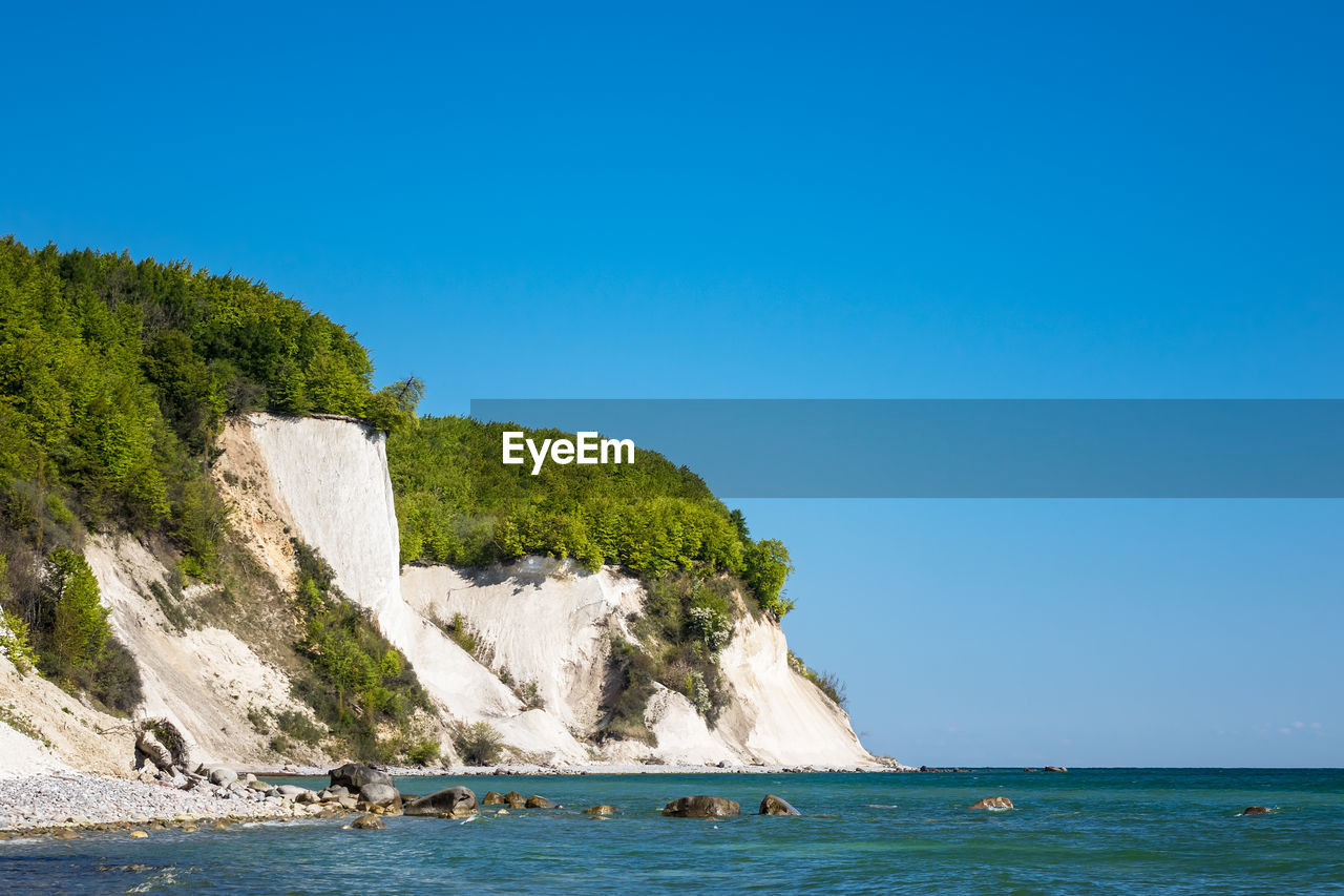 Scenic view of sea against clear blue sky