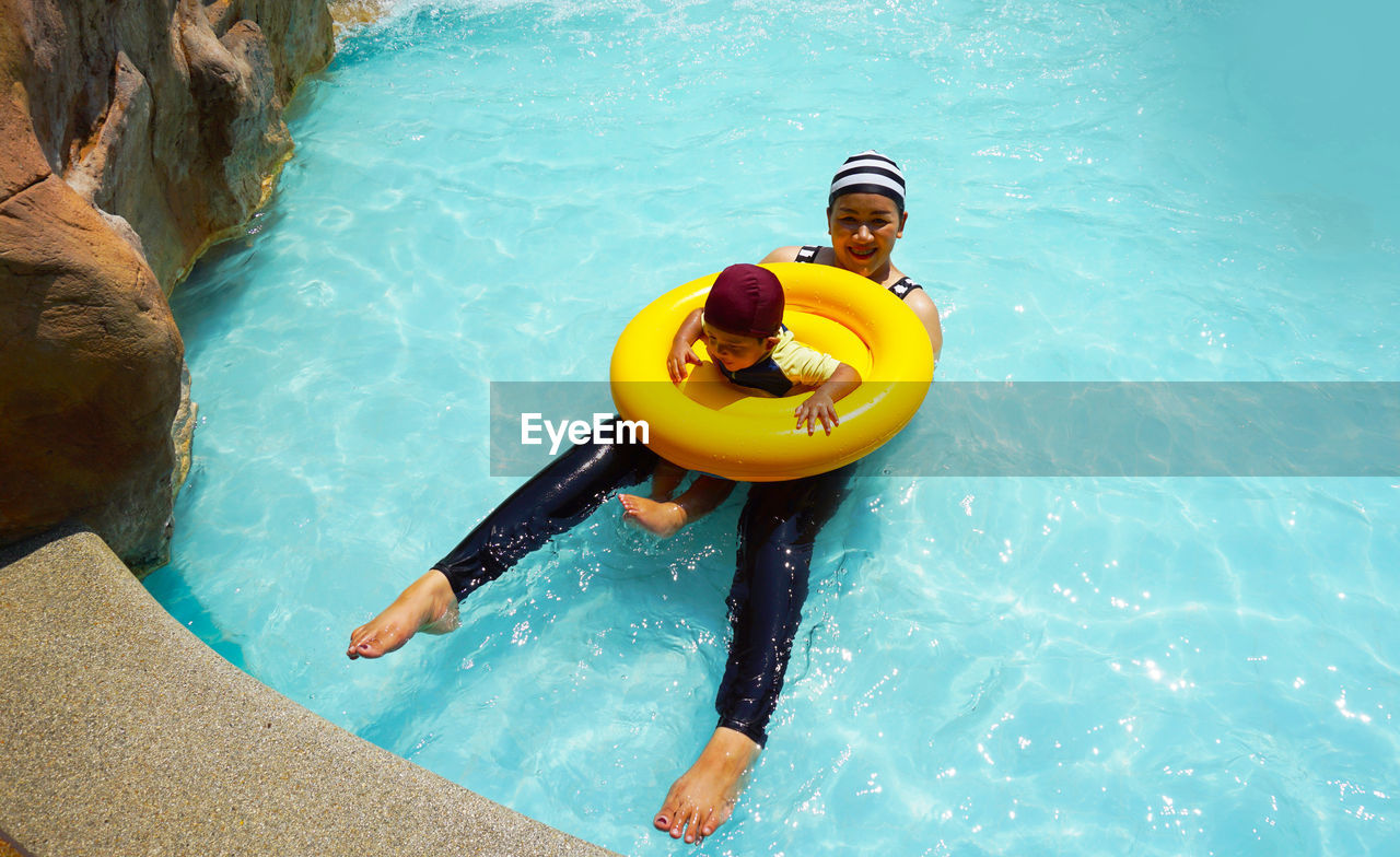 High angle view of woman with son in swimming pool at tourist resort