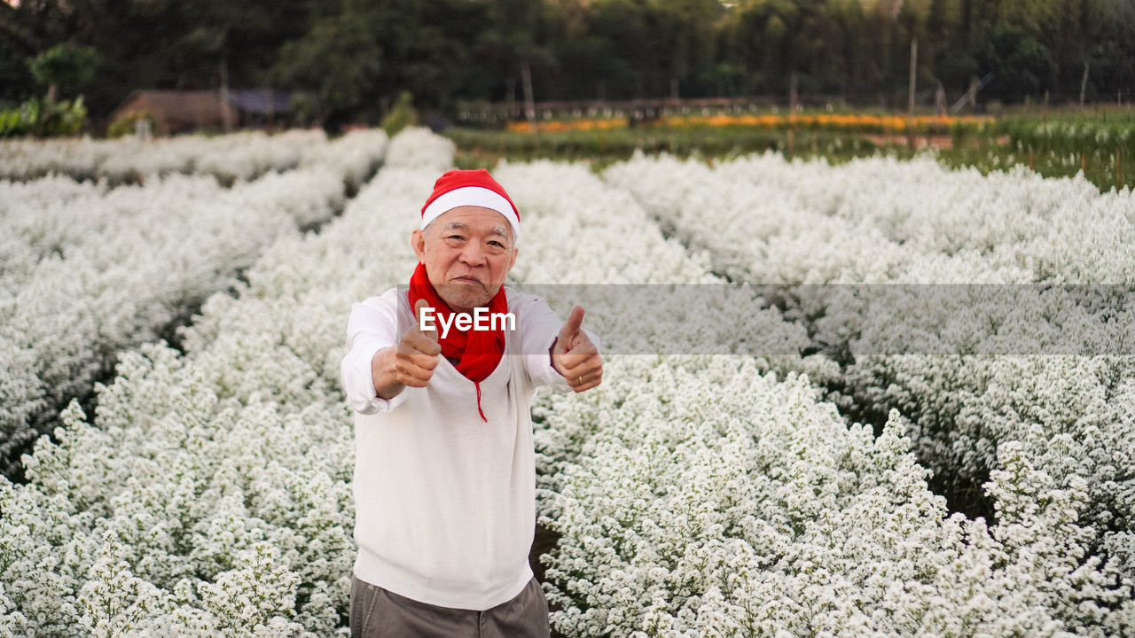 Asian senior elderly man celebrating christmas holiday season white flower and red happiness emotion