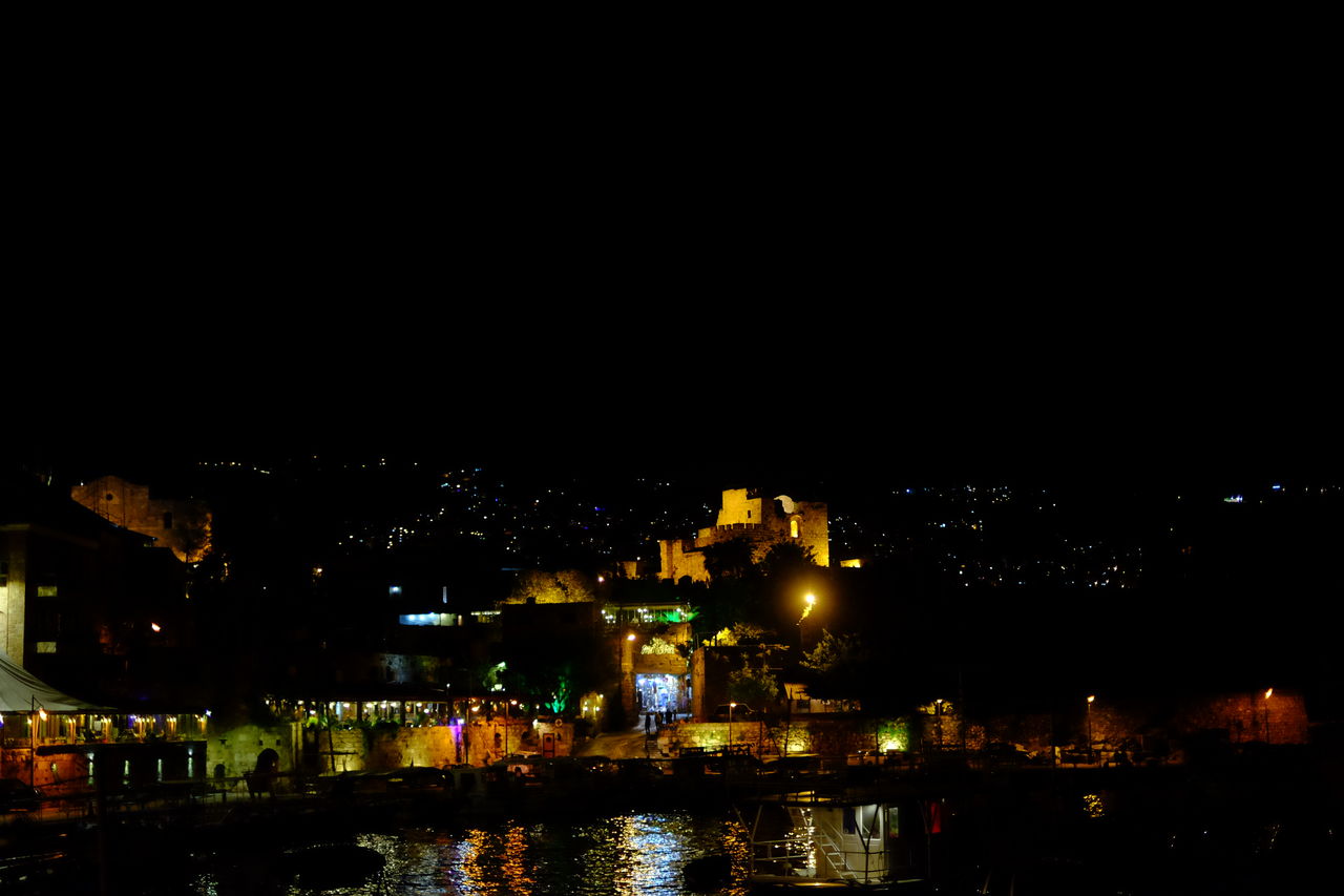 Illuminated cityscape against clear sky at night