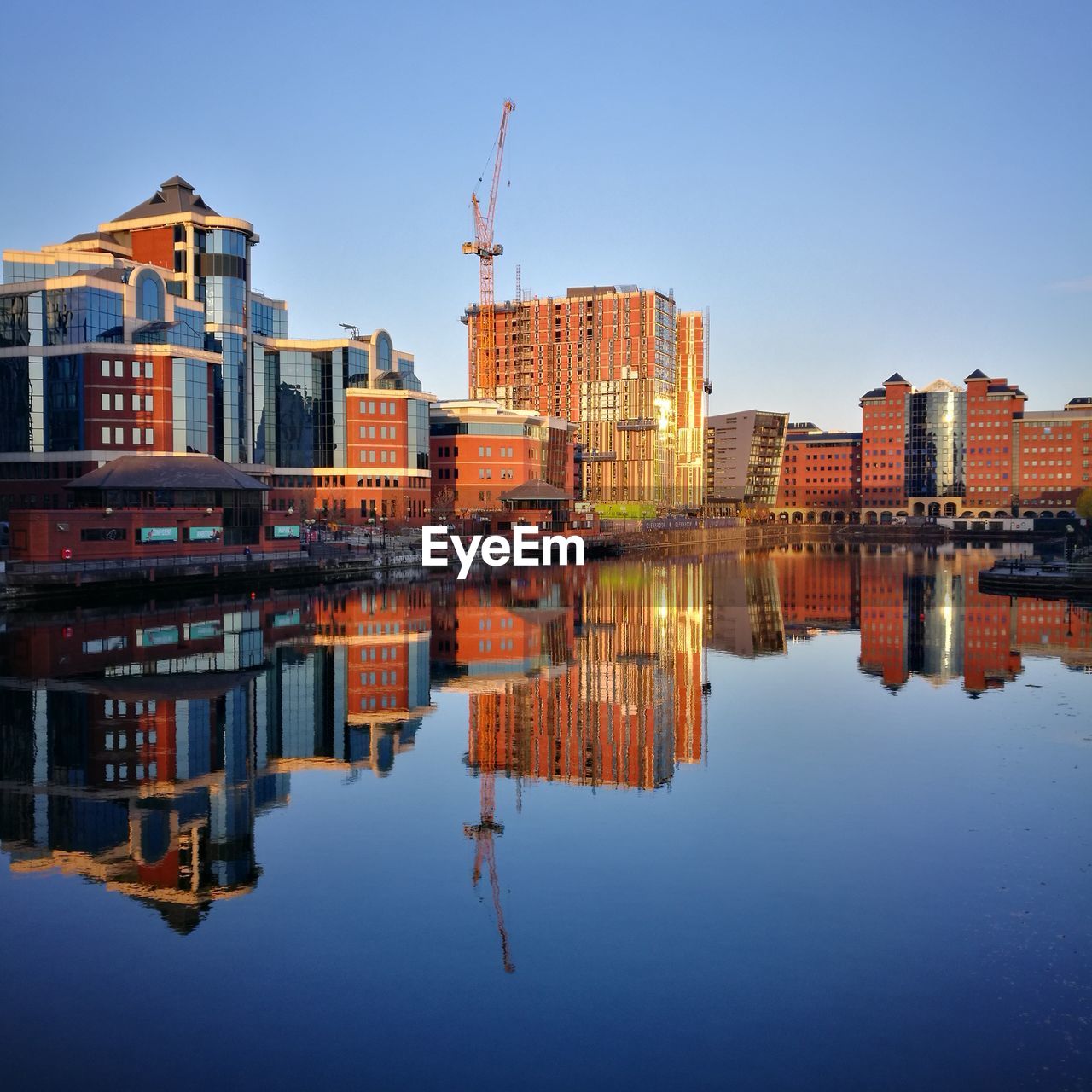 Reflection of buildings in city against sky