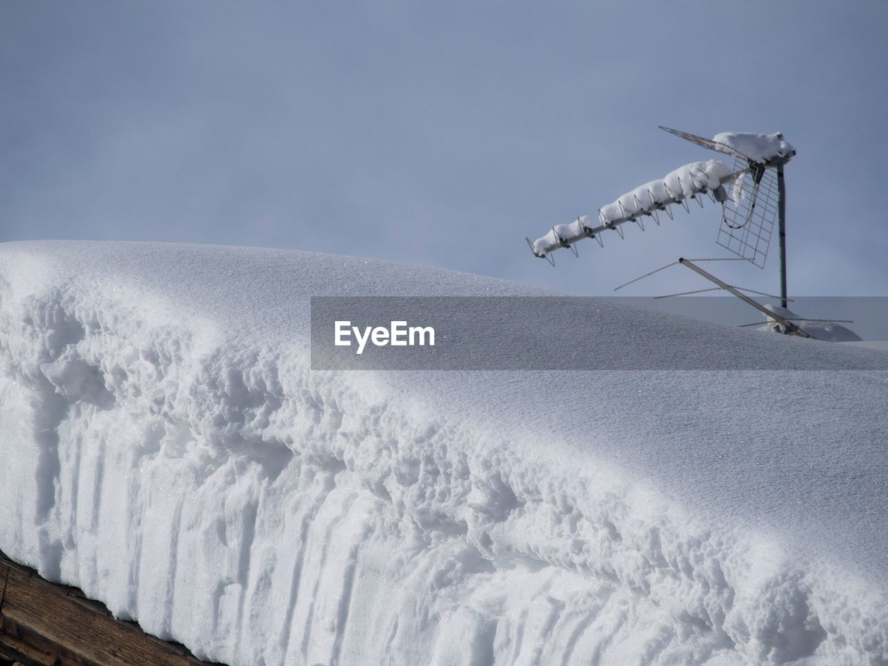 LOW ANGLE VIEW OF SNOW ON WIND AGAINST SKY