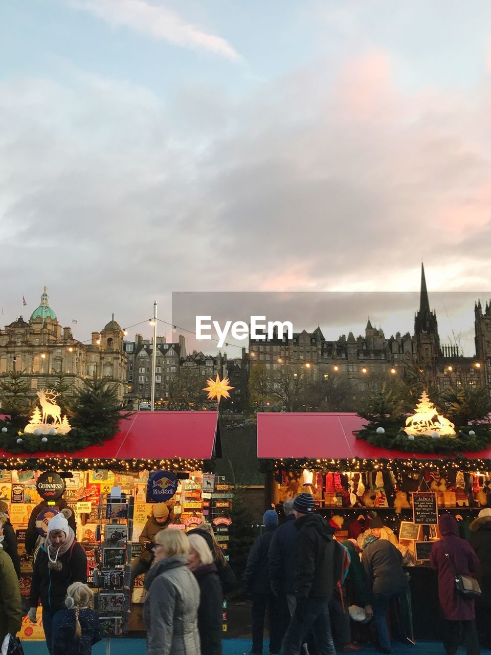 PEOPLE AT MARKET AGAINST SKY IN CITY