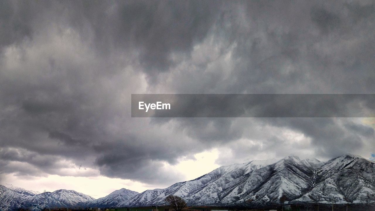 mountain, cloud, environment, sky, snow, beauty in nature, scenics - nature, cold temperature, landscape, winter, mountain range, storm, snowcapped mountain, nature, dramatic sky, no people, storm cloud, travel destinations, overcast, mountain peak, outdoors, extreme weather, cloudscape, land, travel