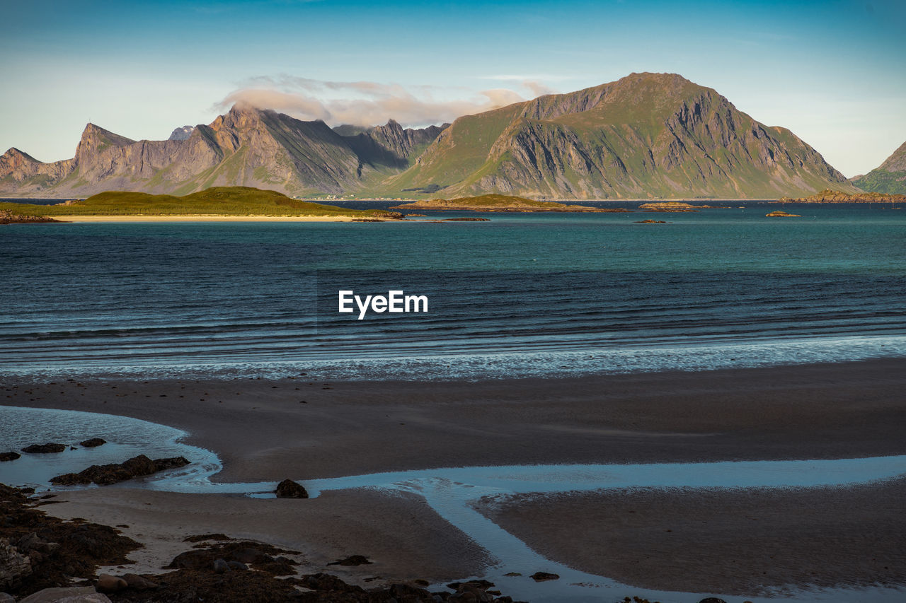 SCENIC VIEW OF SEA AGAINST MOUNTAINS