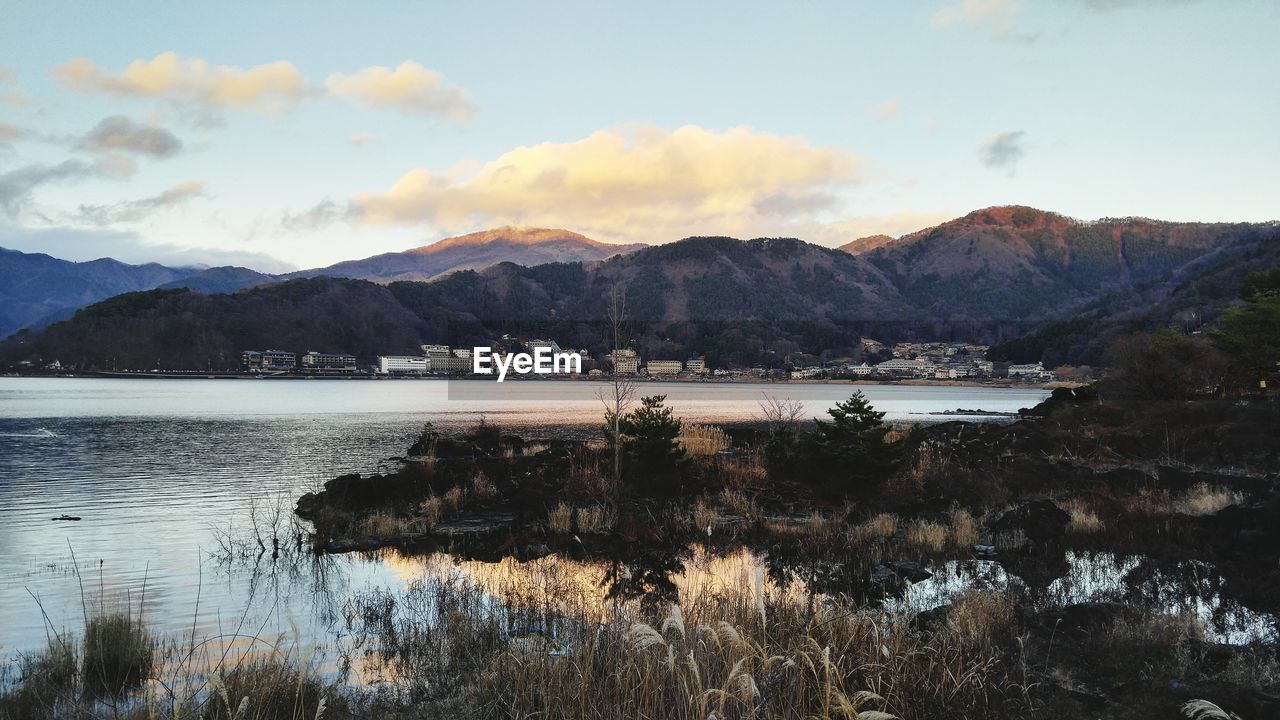 Scenic view of lake by mountains against sky