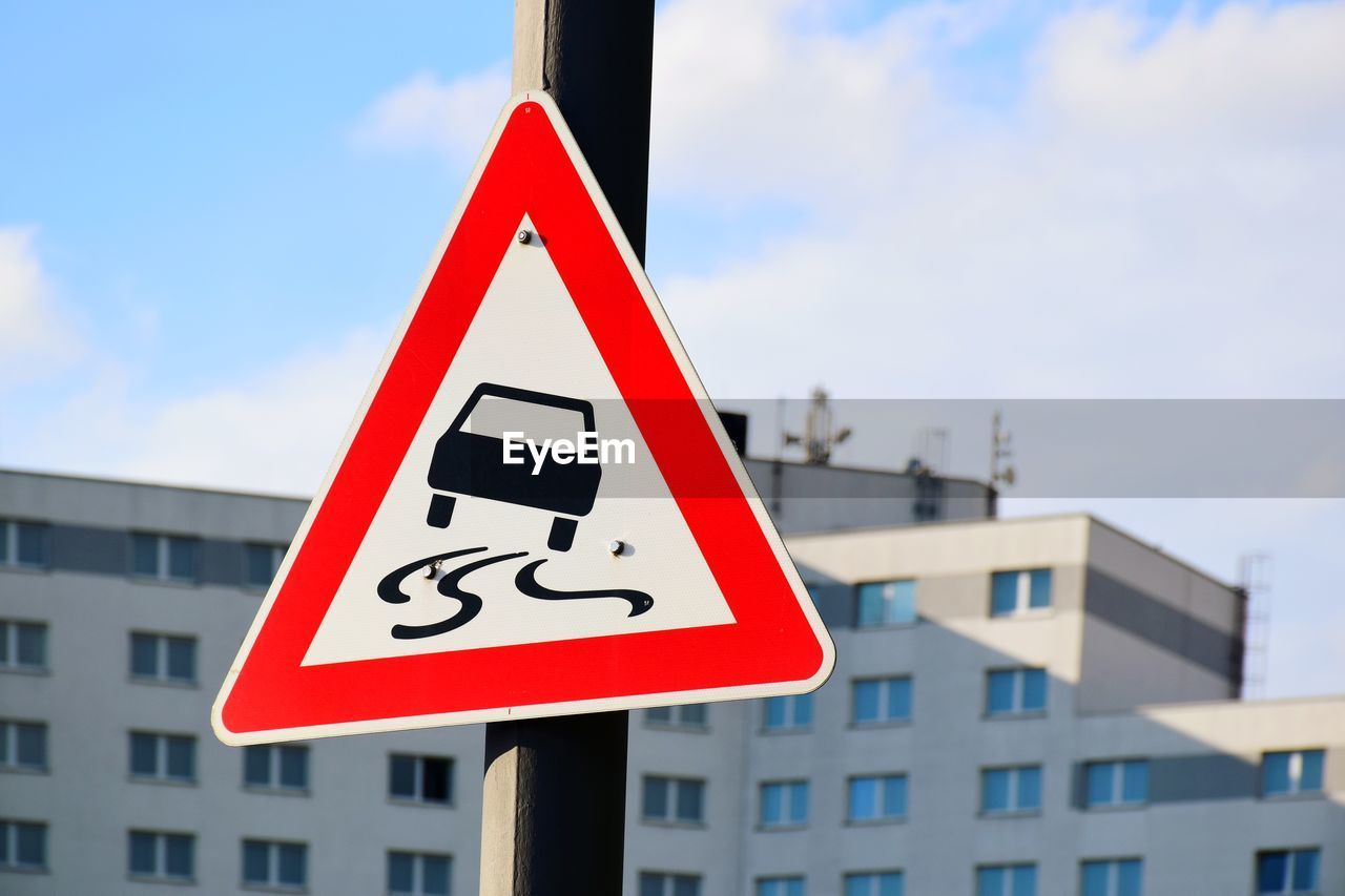 Road sign against sky in city