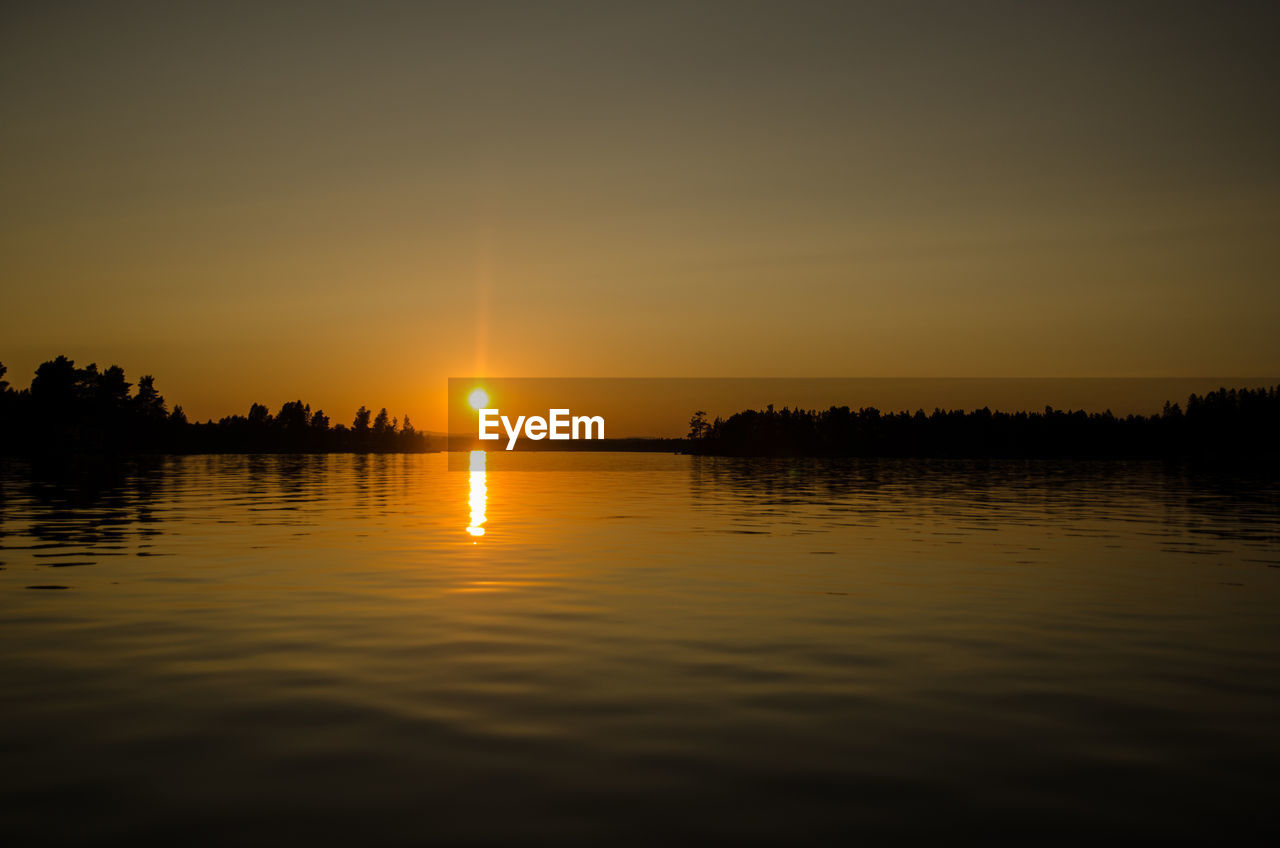 SCENIC VIEW OF LAKE AGAINST ORANGE SKY DURING SUNSET