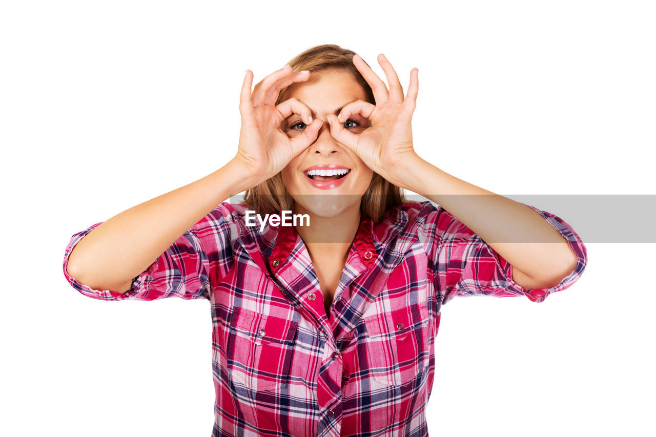 Portrait of cheerful woman gesturing against white background