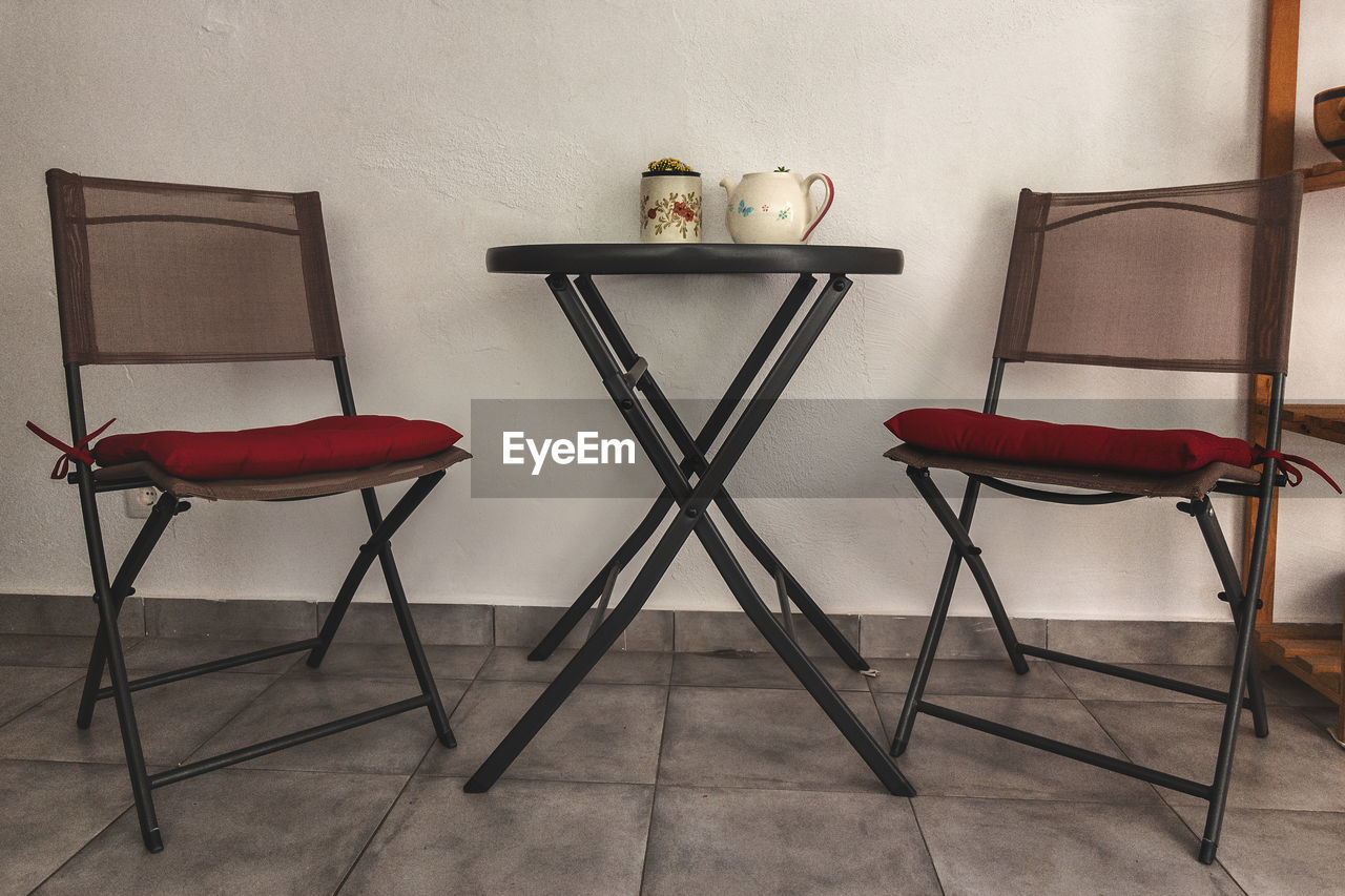 Empty chairs and tables against wall at home