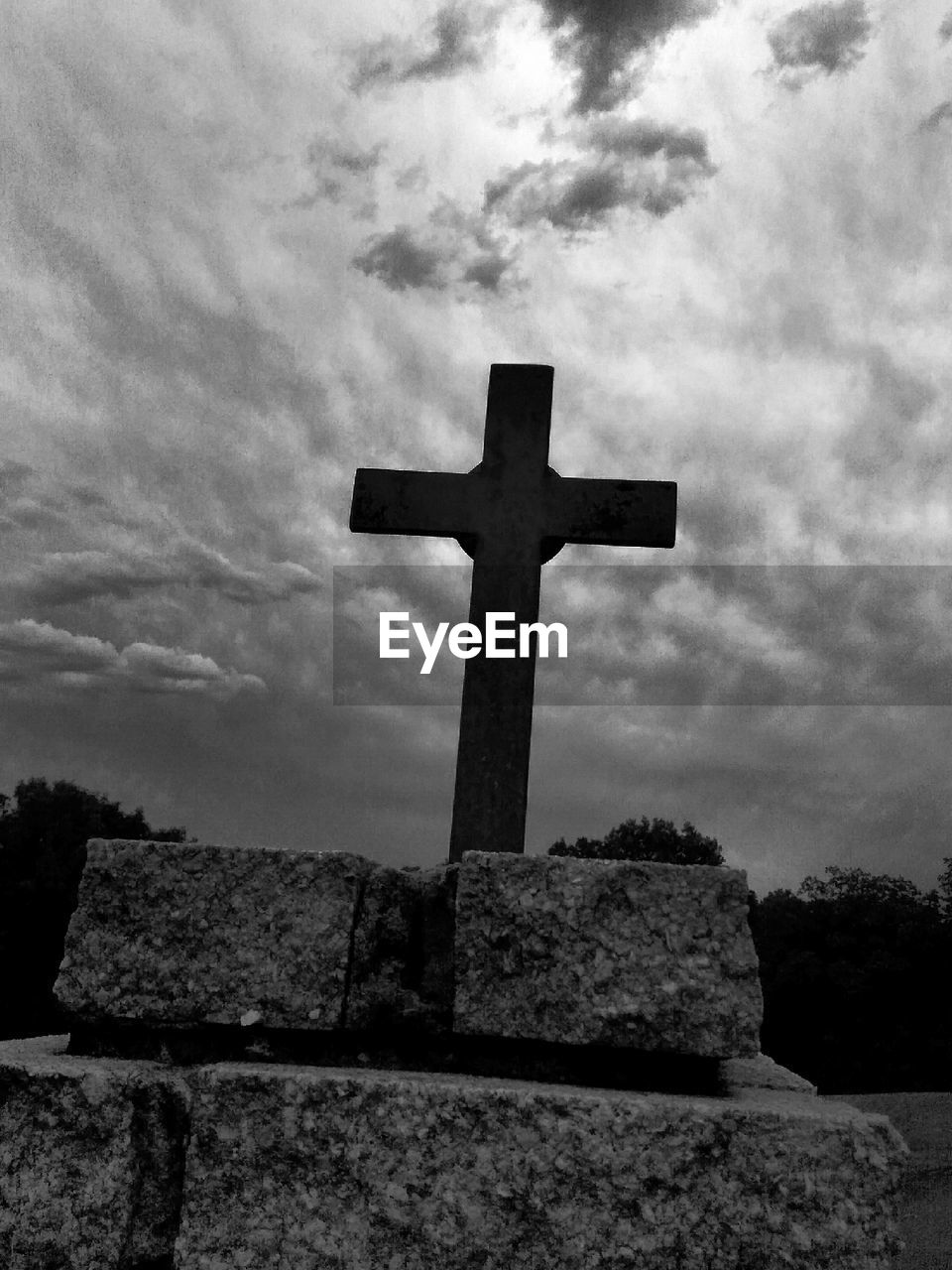 LOW ANGLE VIEW OF CROSS ON CEMETERY AGAINST SKY