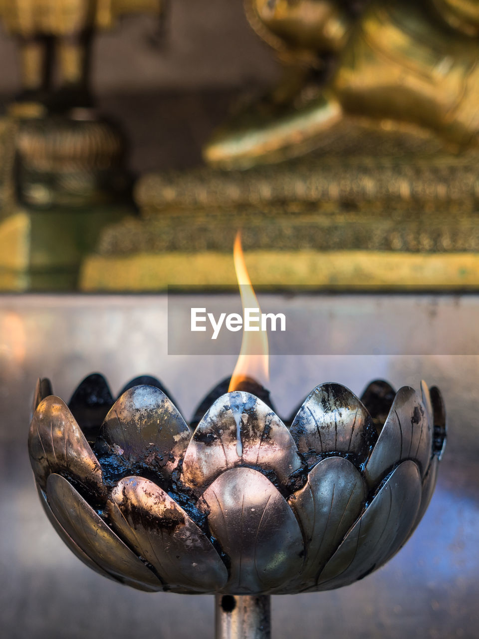 Close-up of burning oil candle in buddhist temple, chiang mai, thailand