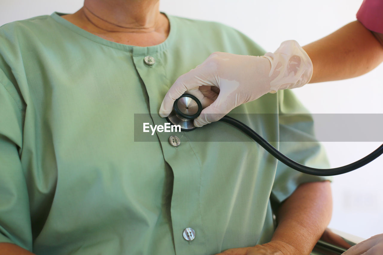 midsection of doctor holding stethoscope