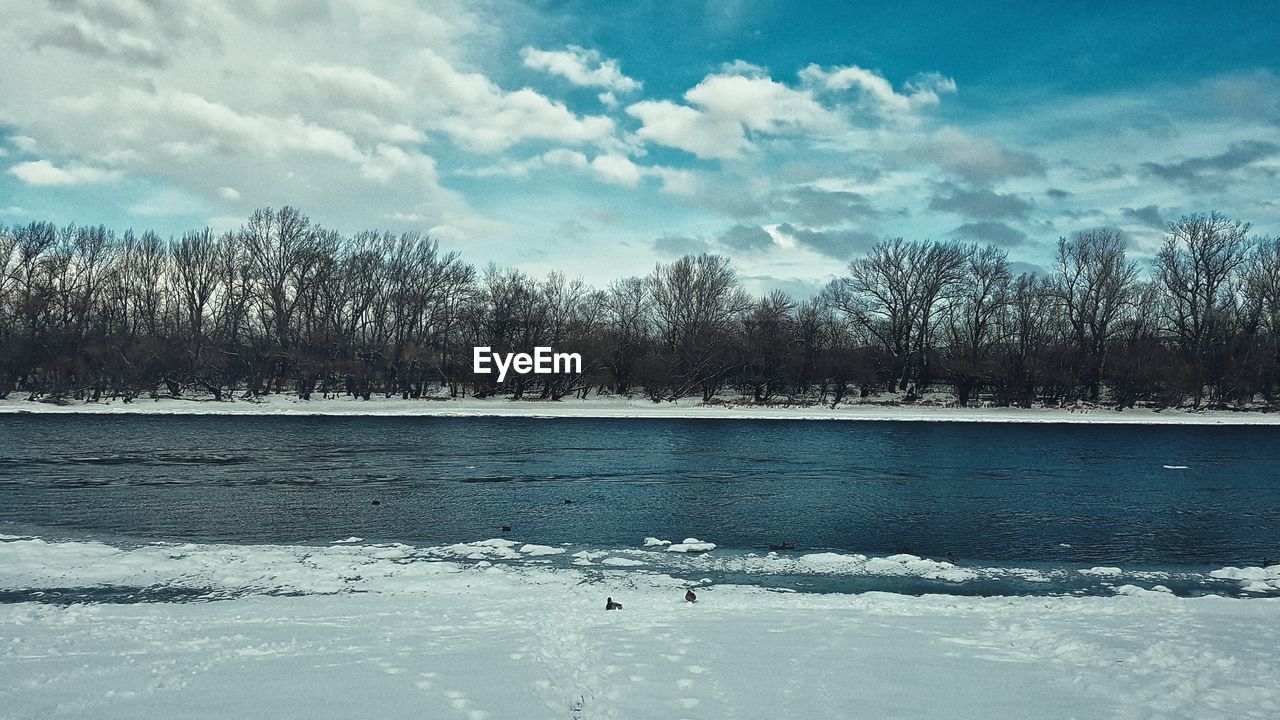 FROZEN LAKE AGAINST SKY DURING WINTER