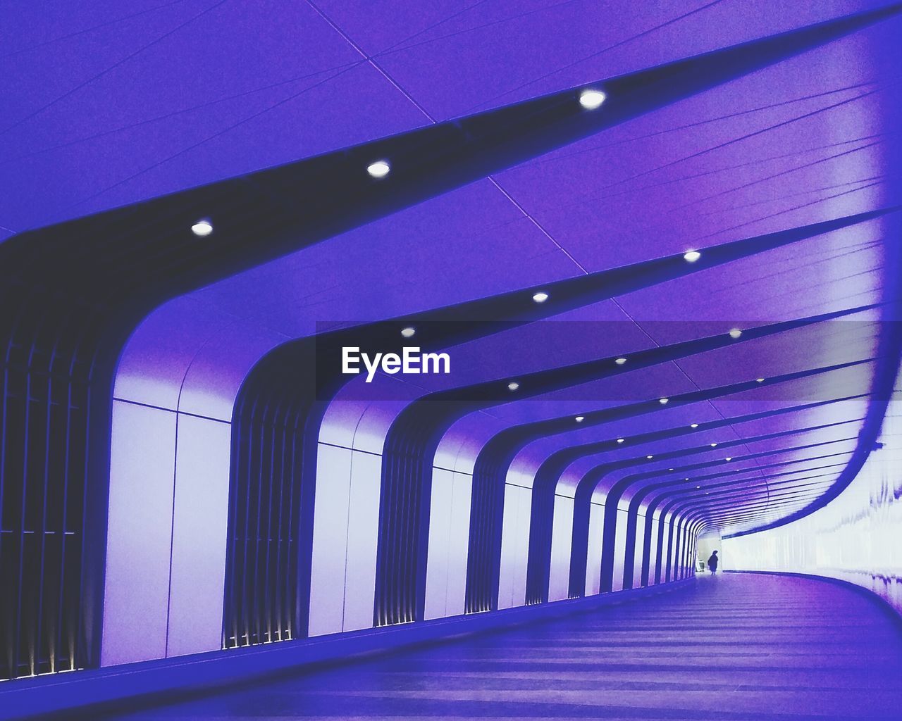 EMPTY WALKWAY LEADING TOWARDS ILLUMINATED TUNNEL
