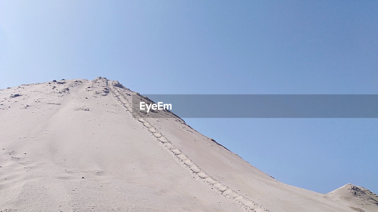 Scenic view of desert against clear blue sky