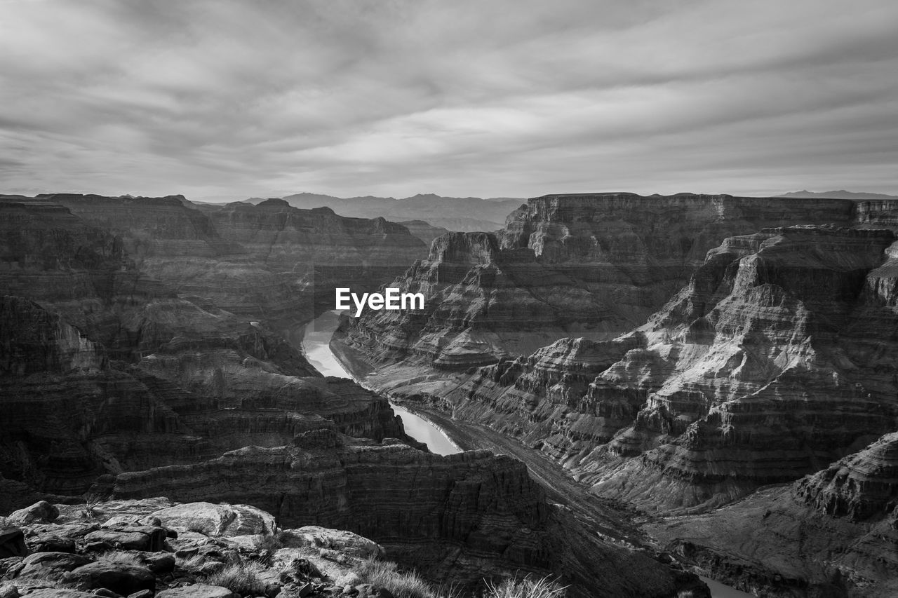 Rock formations on landscape against cloudy sky