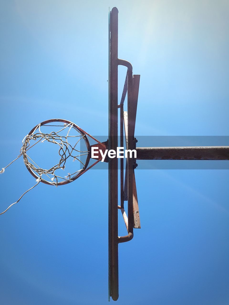 LOW ANGLE VIEW OF BASKETBALL HOOP AGAINST CLEAR SKY