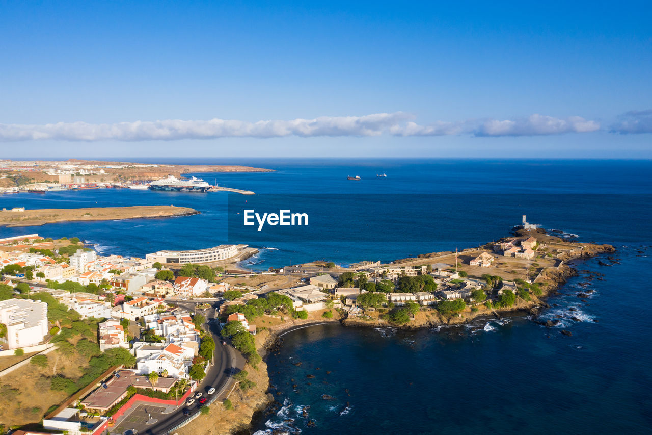 AERIAL VIEW OF CITY BY SEA AGAINST SKY