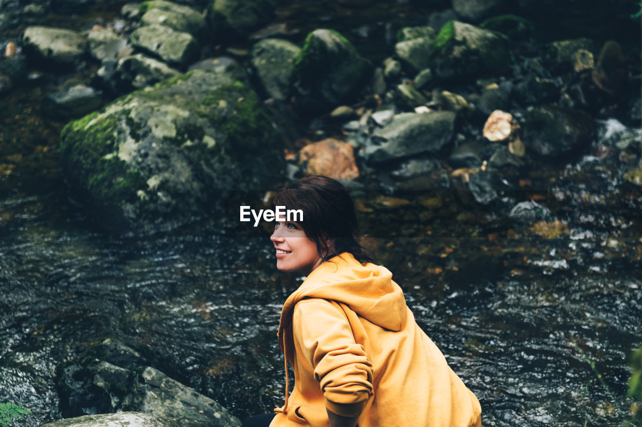 Young woman at aber falls or in welsh rhaeadr fawr is waterfall located at gwynedd, wales