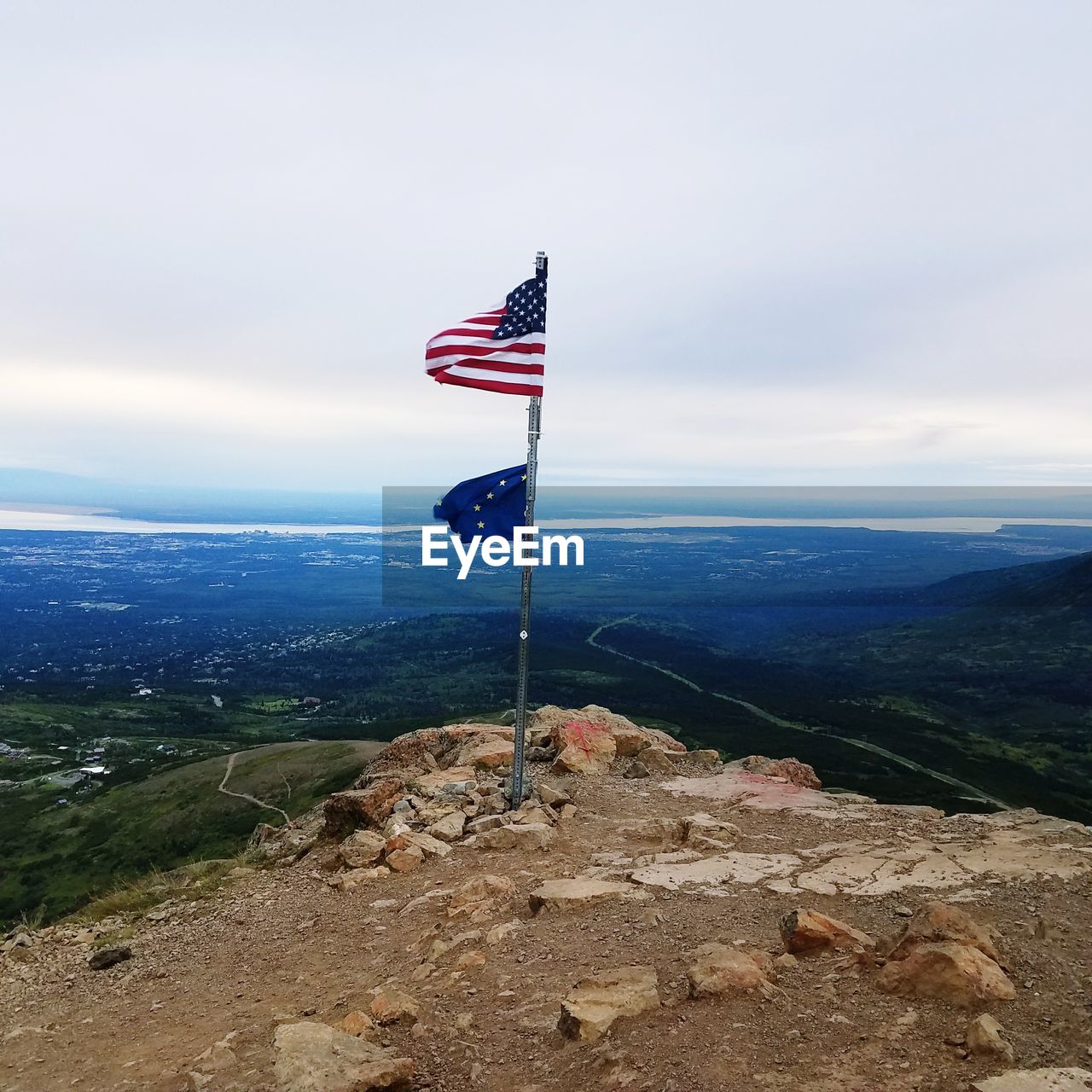 American and european union flags on cliff against landscape