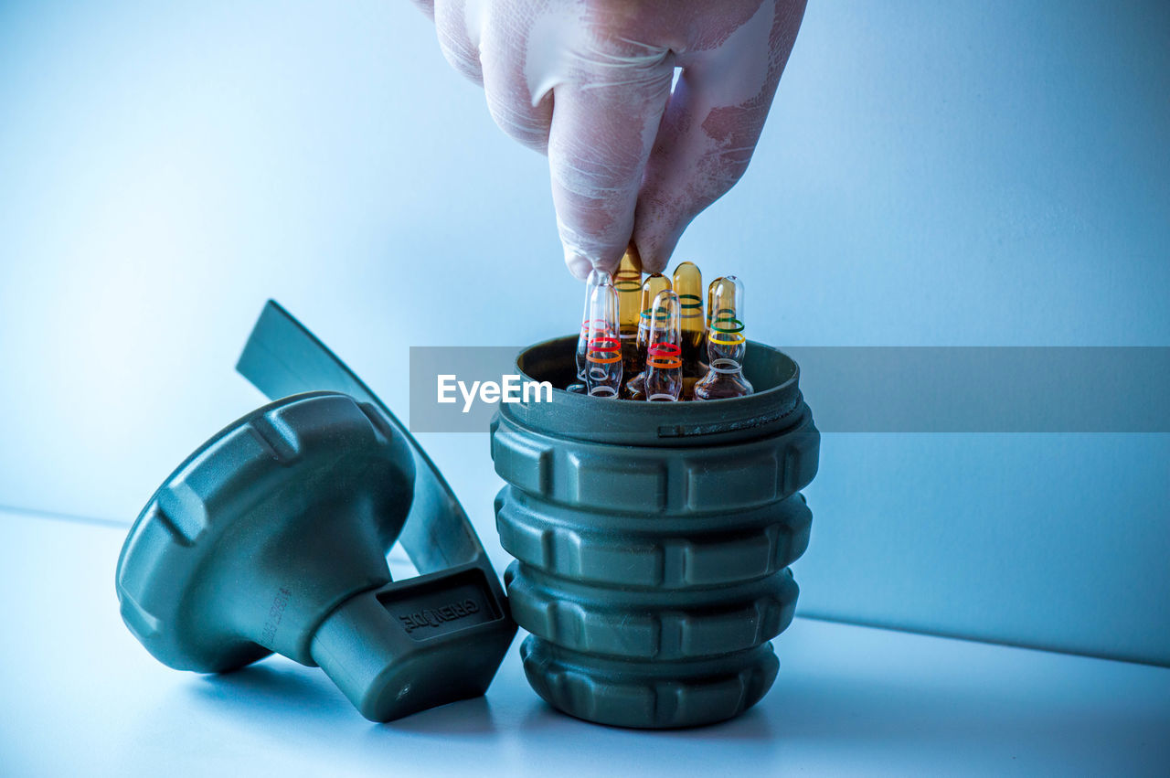 hand, one person, indoors, adult, blue, studio shot, holding, toy, business, technology, occupation