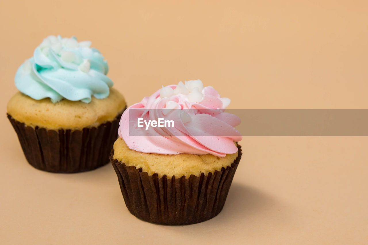Close-up of cupcakes against colored background