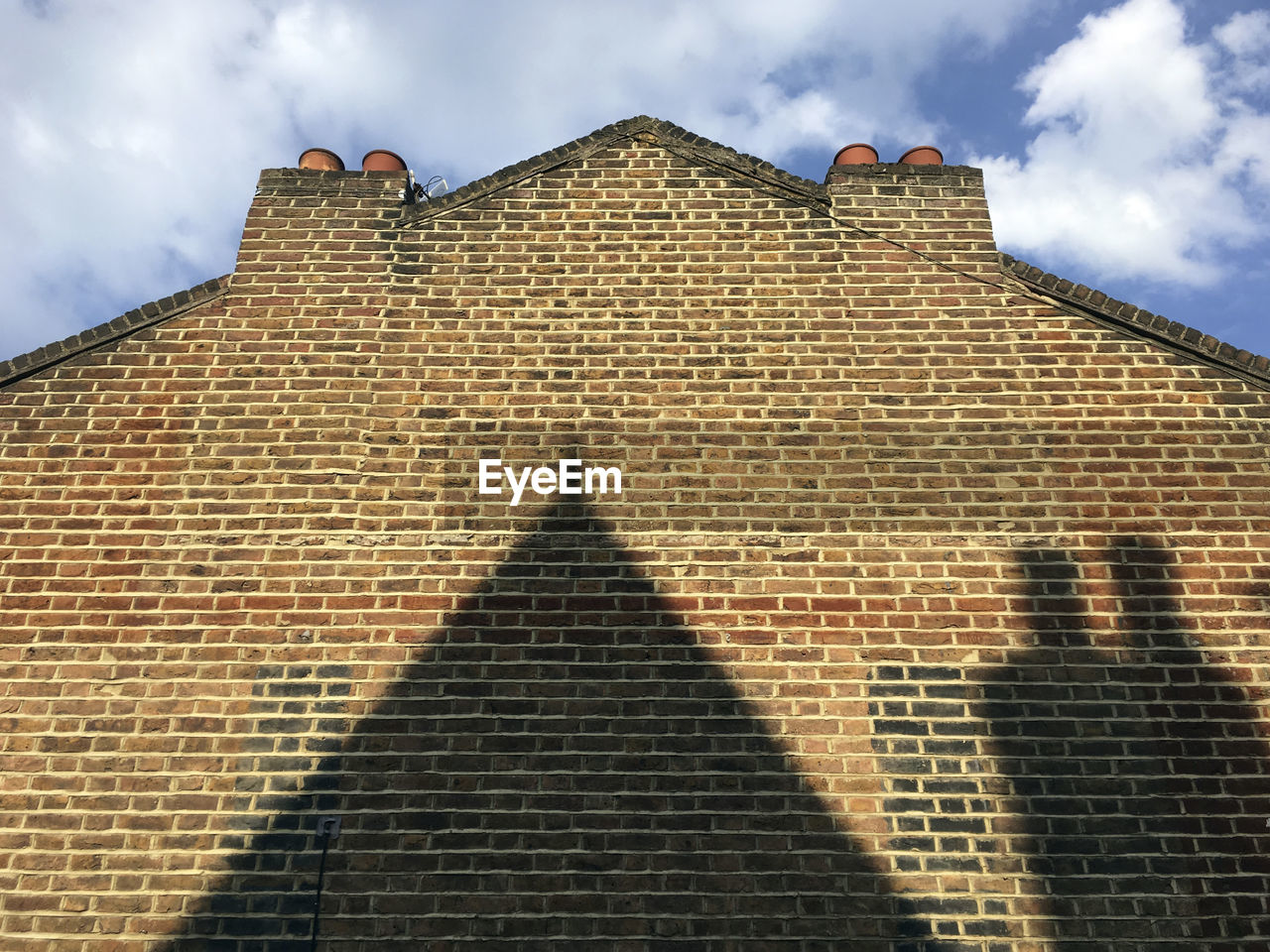 Shadow on wall of building against sky