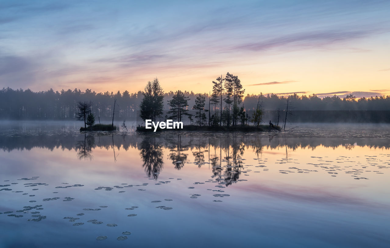 Scenic view of lake against sky at sunset